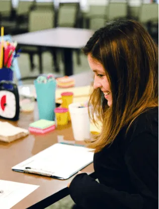 Researcher taking notes alongside a participant during a workshop
