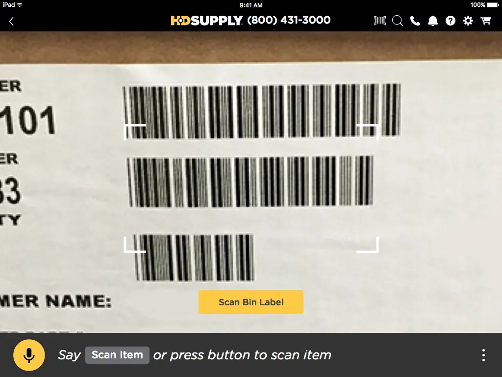 Barcode scanning interface for item identification showing camera viewfinder with Scan Bin Label button and voice prompt to scan item