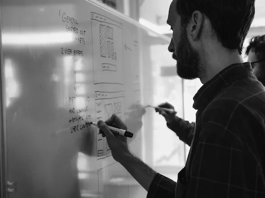 Designer sketching on whiteboard