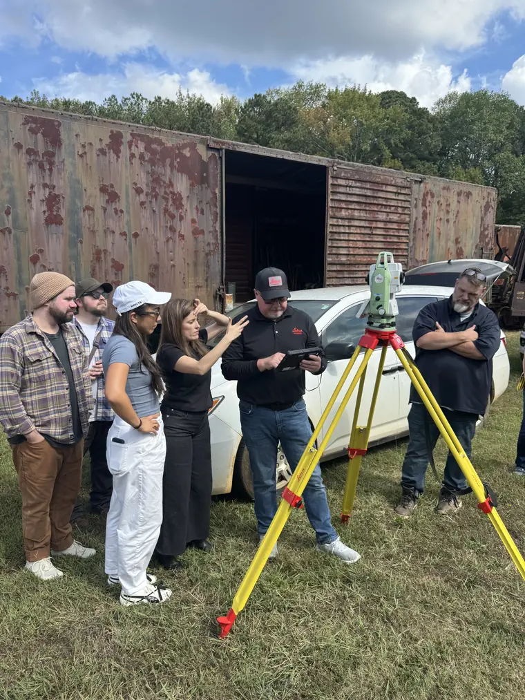 The Digital Scientists team testing the rebuilt Safeload app on a tablet beside a Total Station and a rail boxcar during a field trial