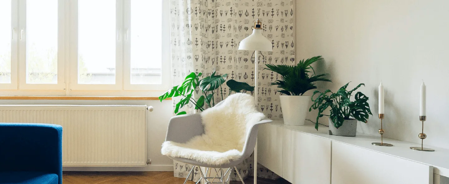 Modern living room with automated smart shades controlled by the ShadeHub mobile app, showing blinds at various positions