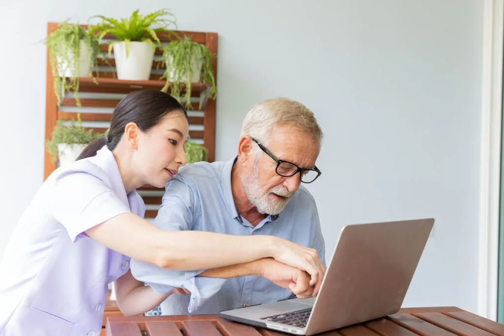 Healthcare professional helping patient with digital health technology