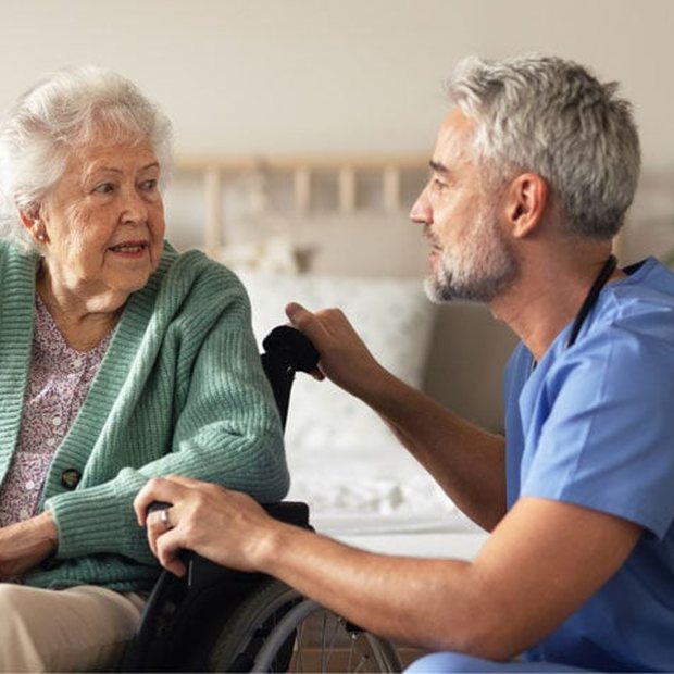 A nurse talking with a resident in a wheelchair