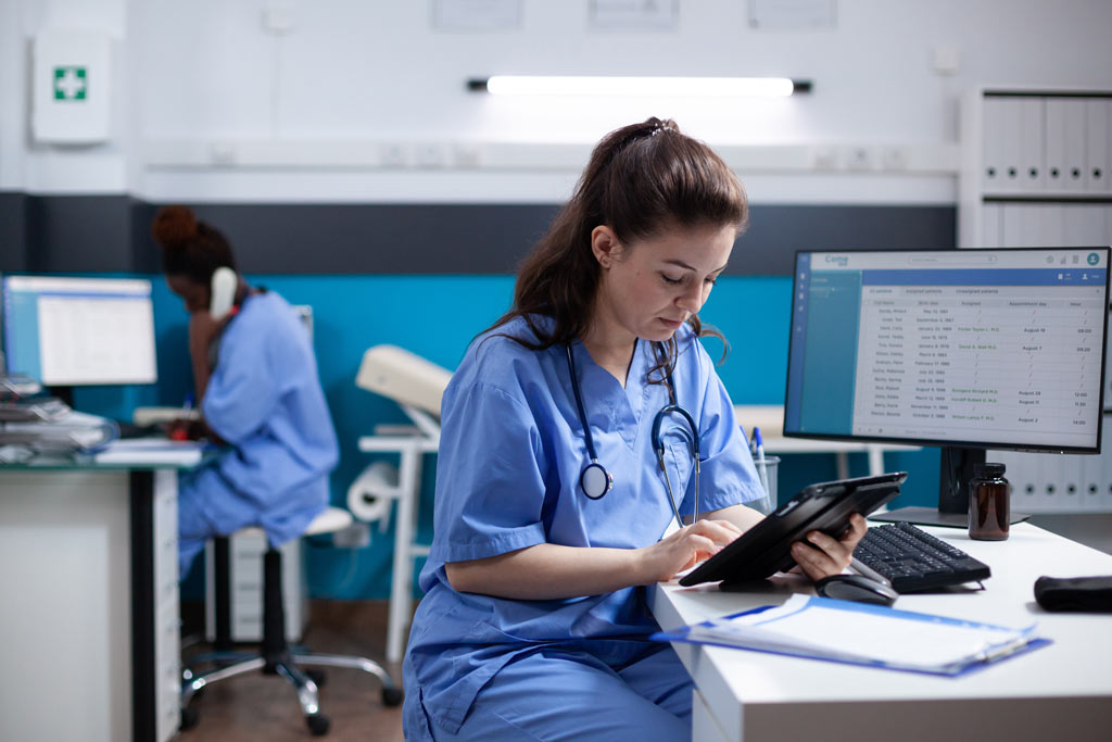 Nurse checks a healthcare app on her tablet, using one of the most common technologies in healthcare.