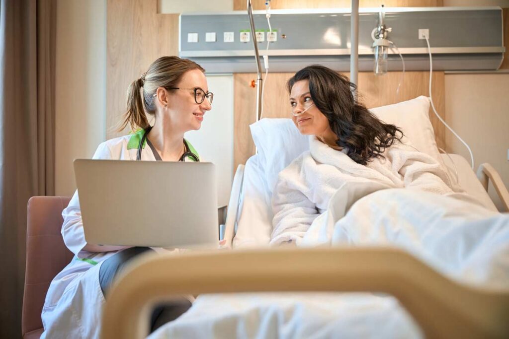 A doctor talking to a patient in her hospital bed