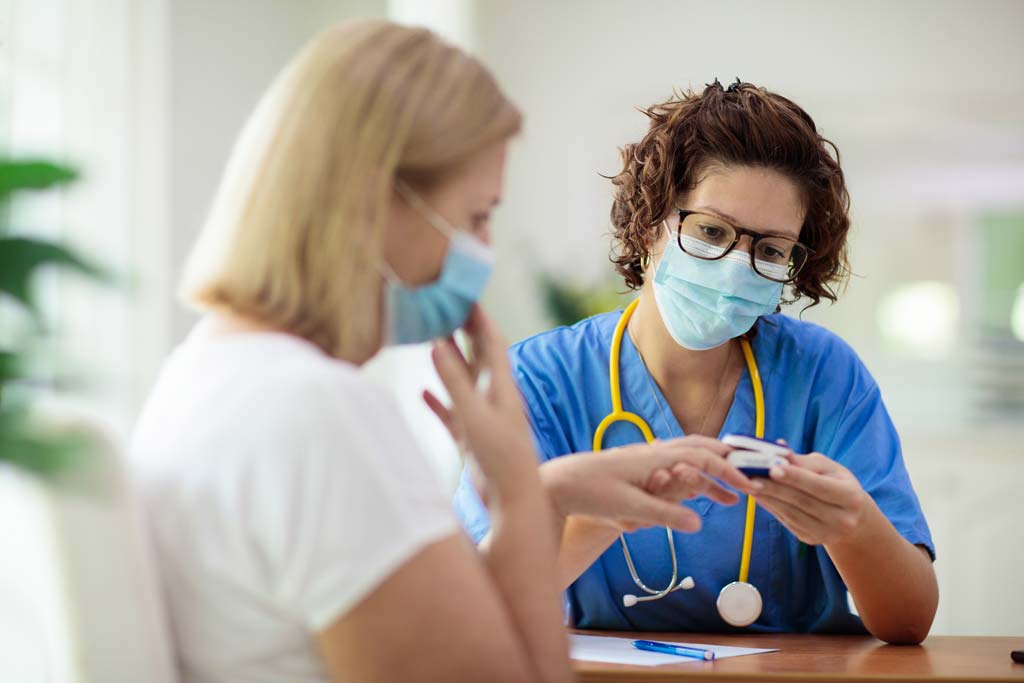 Doctor measures patient pulse and oxygen levels using healthcare tech (pulse oximeter)