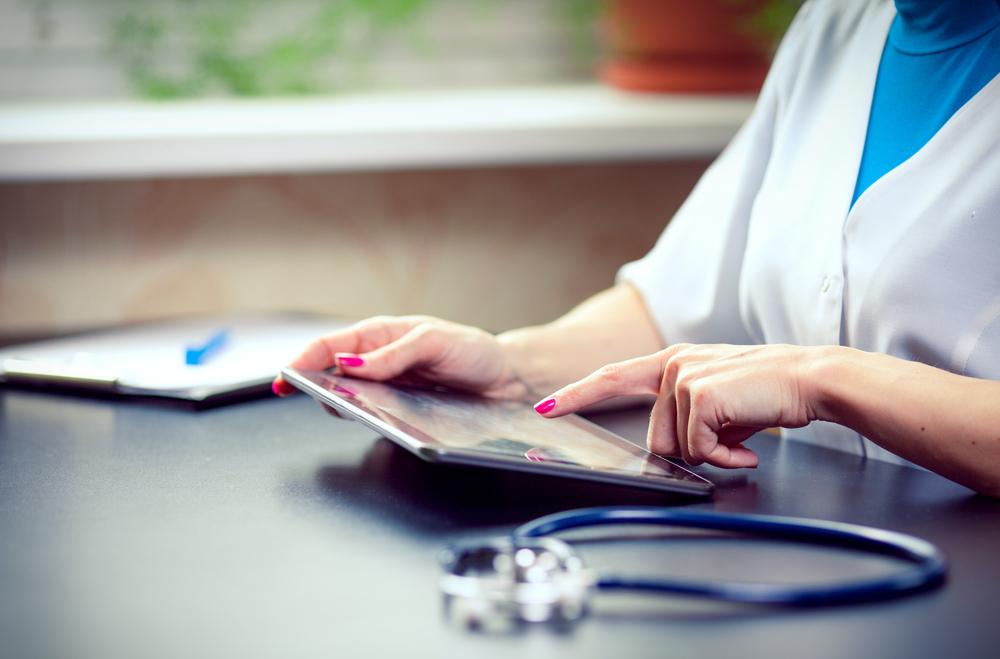 Woman doctor using tablet computer in hospital