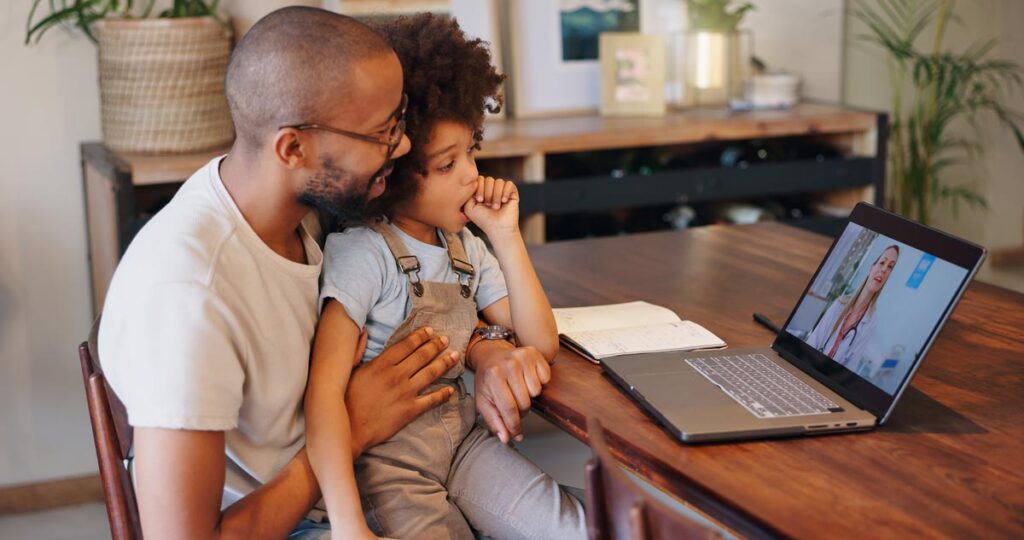A father and daughter having a telehealth appointment with a pediatrician