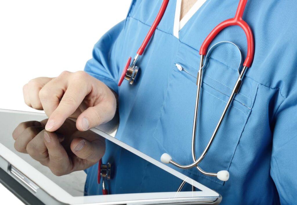Doctor uses tablet to check patient in demonstrating the use of mobile technology in healthcare